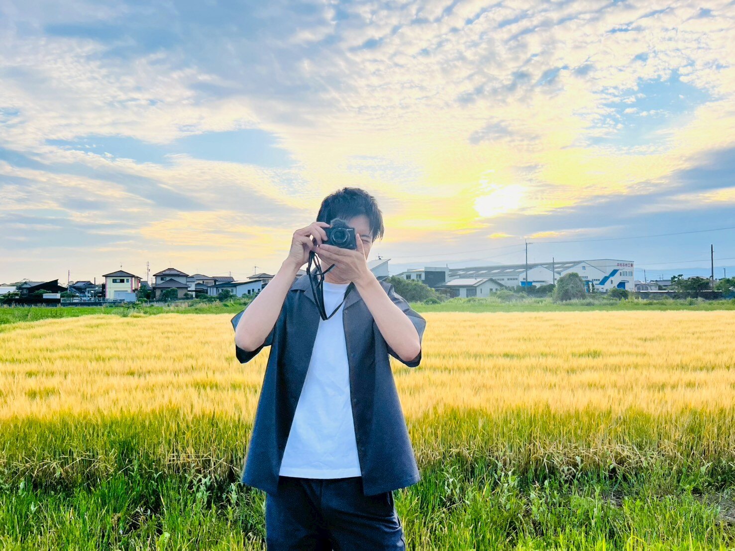 福岡の風景の中でカメラを構えるT-CREATEの制作者